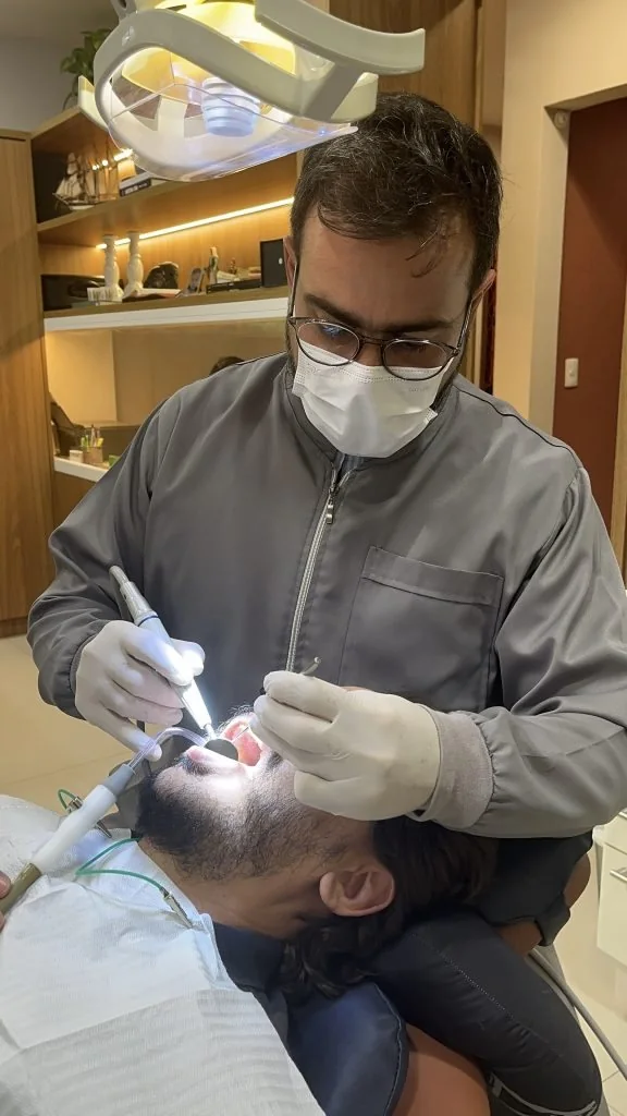 Dr. Paulo Melo realizando um procedimento em seu consultório